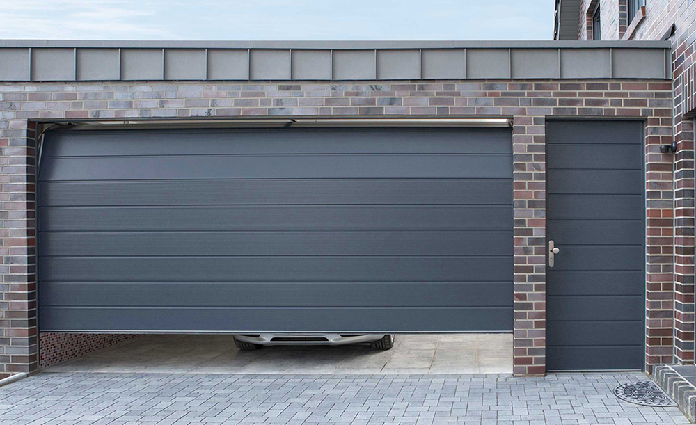 Sectional garage door with side hinged personnel door